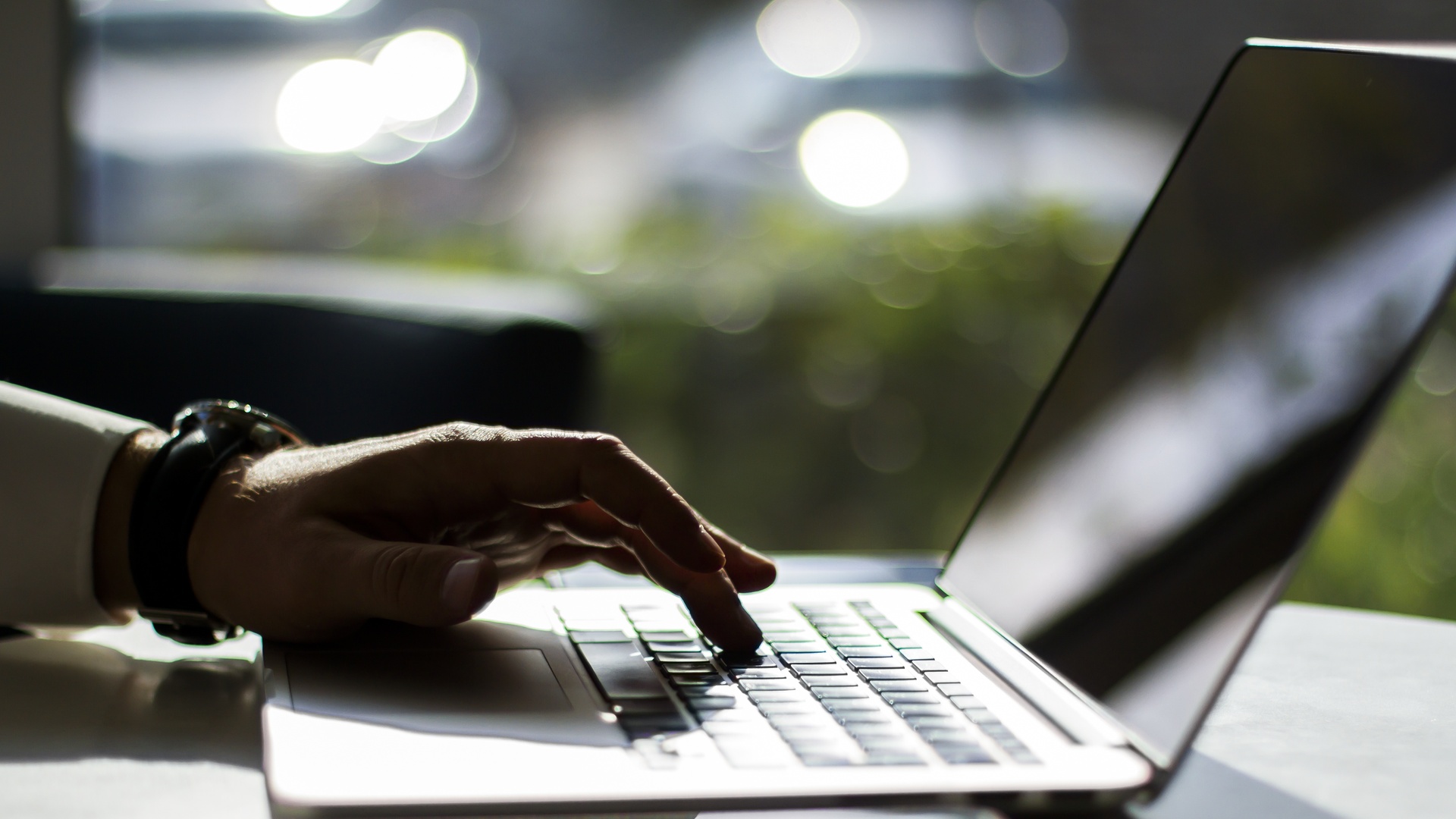 Businessman pushing a button on a laptop keyboard, close up