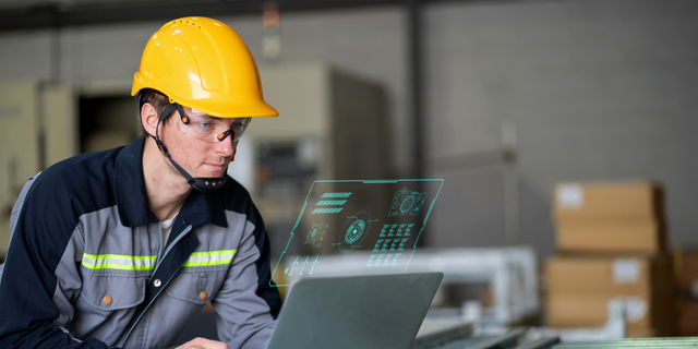 A robotics engineer closely monitors the progress of installation program for robotic arm via a digitization display, ensuring precision in the manufacturing of a robotic arm part. Integration of advanced technology and human expertise in an automated