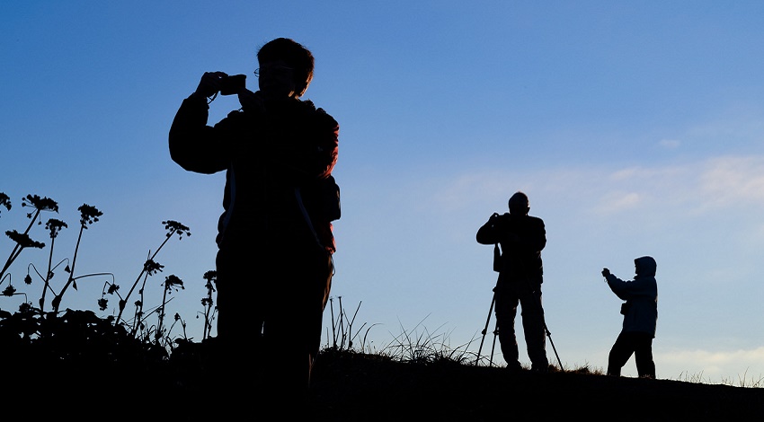 A group of photographers taking pictures with various camera equipment