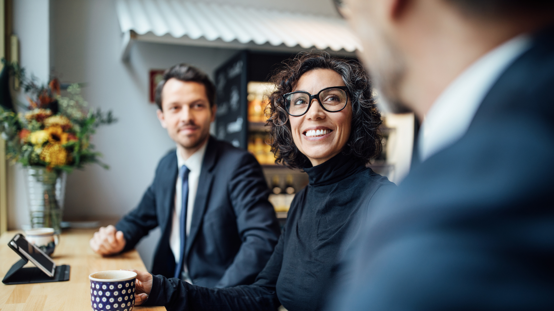 Group of three business people sitting at a coffee shop