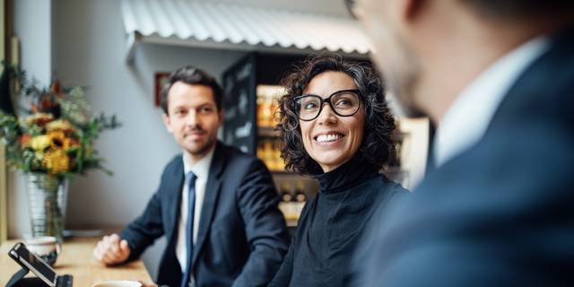 Group of three business people sitting at a coffee shop