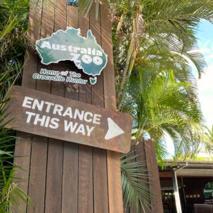 The outside of Australia Zoo. There is a sign saying "entrance this way" with an arrow.