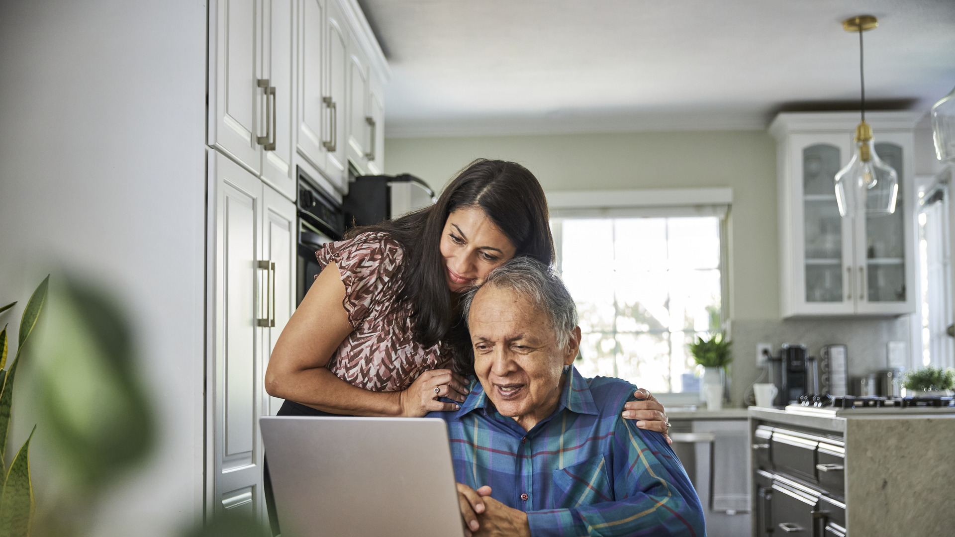 Daughter assisting father on how to use the computer