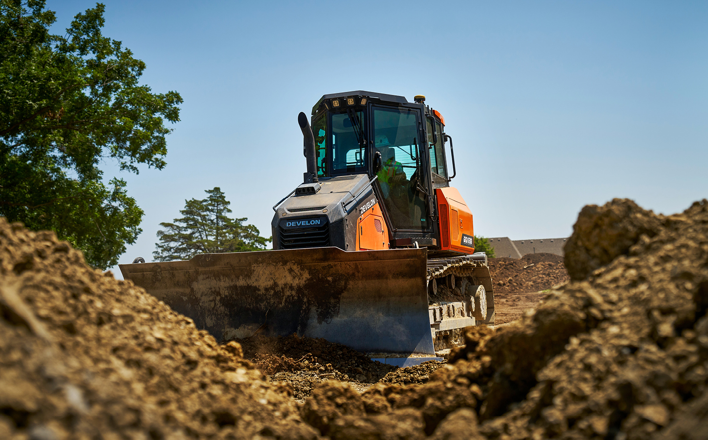 DEVELON dozer pushes dirt on a jobsite. 