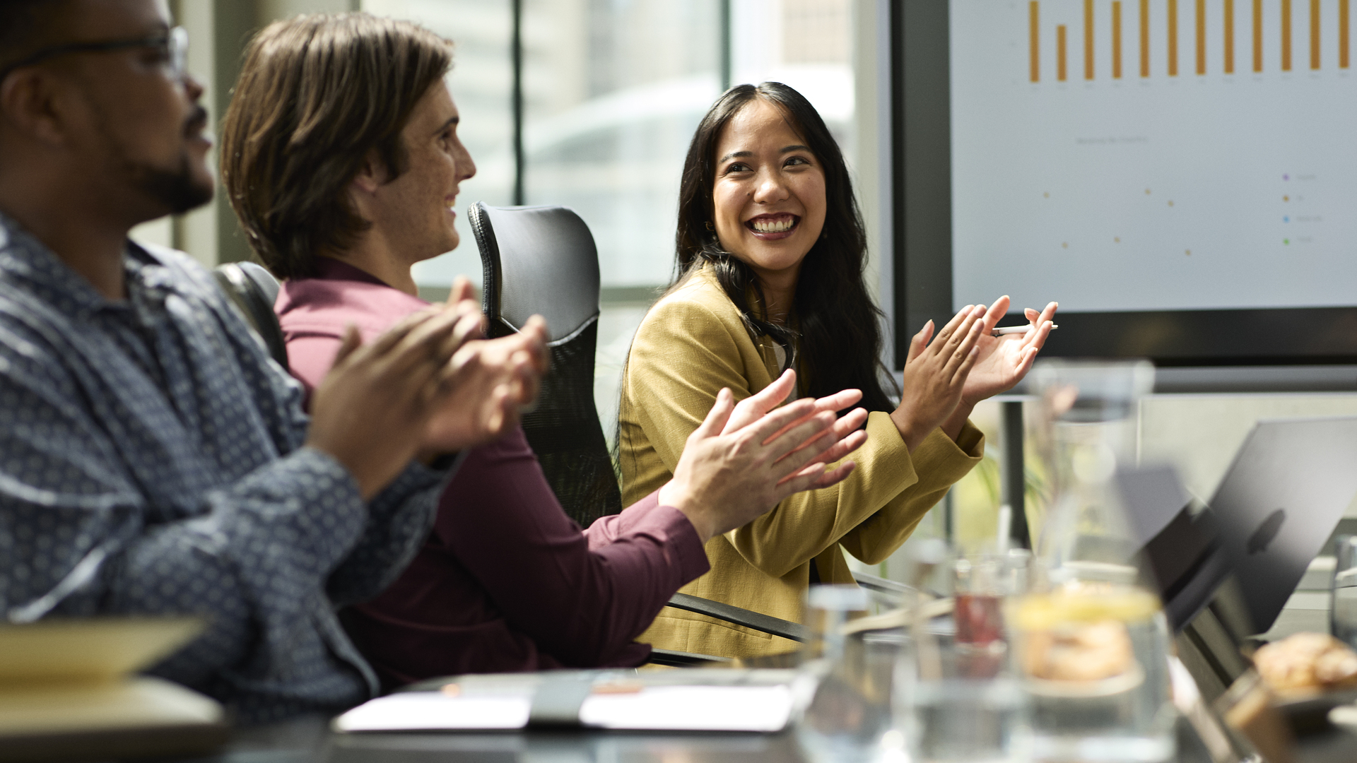 Happy businesswoman clapping in meeting room