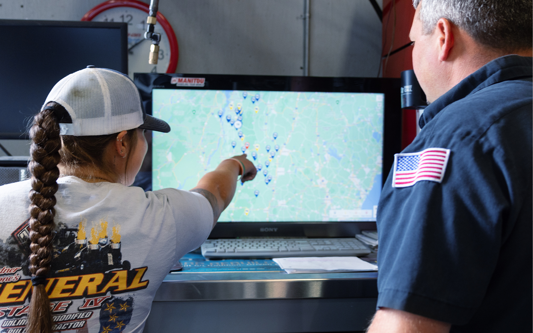 Two equipment dealer team members looking at a heavy equipment telematics map.