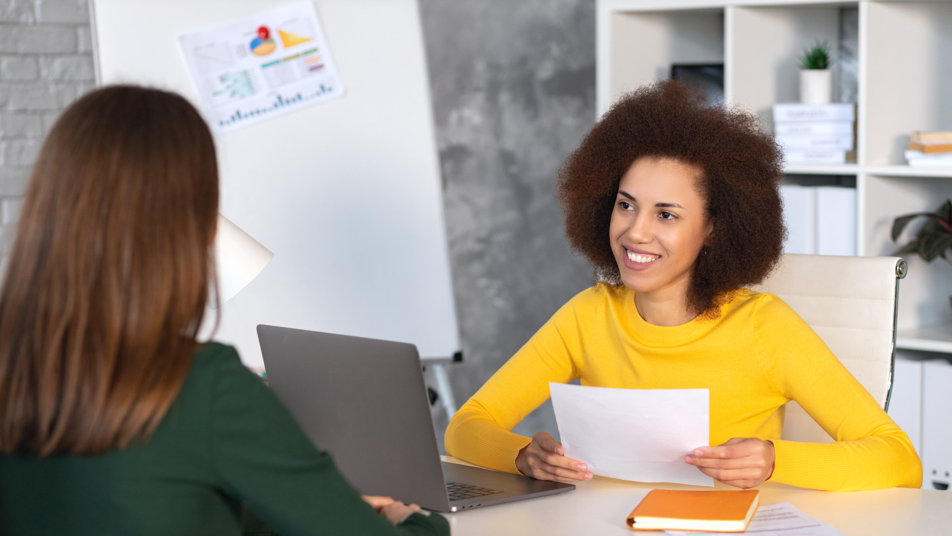 Interview between businesswoman hr director and job candidate. Recruitment manager holding paper cv and talking hiring for job female