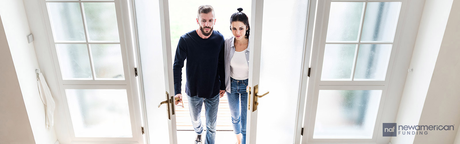 couple walking through french doors into their home