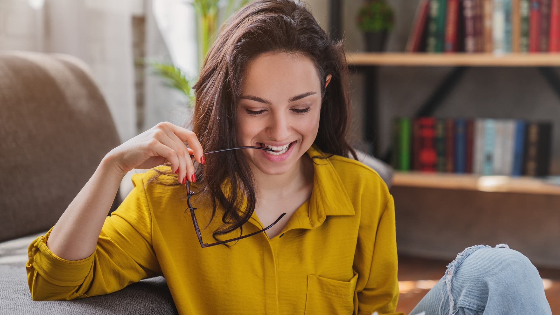 Young smiling woman sitting om floor and checking bills at living room