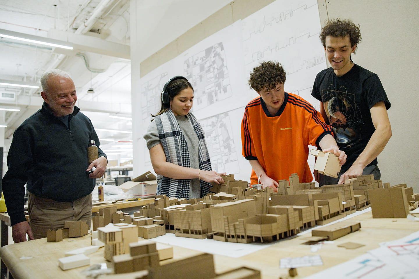 Professor Brian McGrath works with three Parsons students as they assemble a detailed cardboard model of Tainan, Taiwan, created for a course on blockology in the School of Constructed Environments st