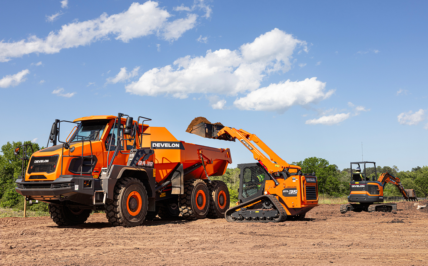 A DEVELON compact track loader, articulated dump truck and mini excavator work together on a jobsite.