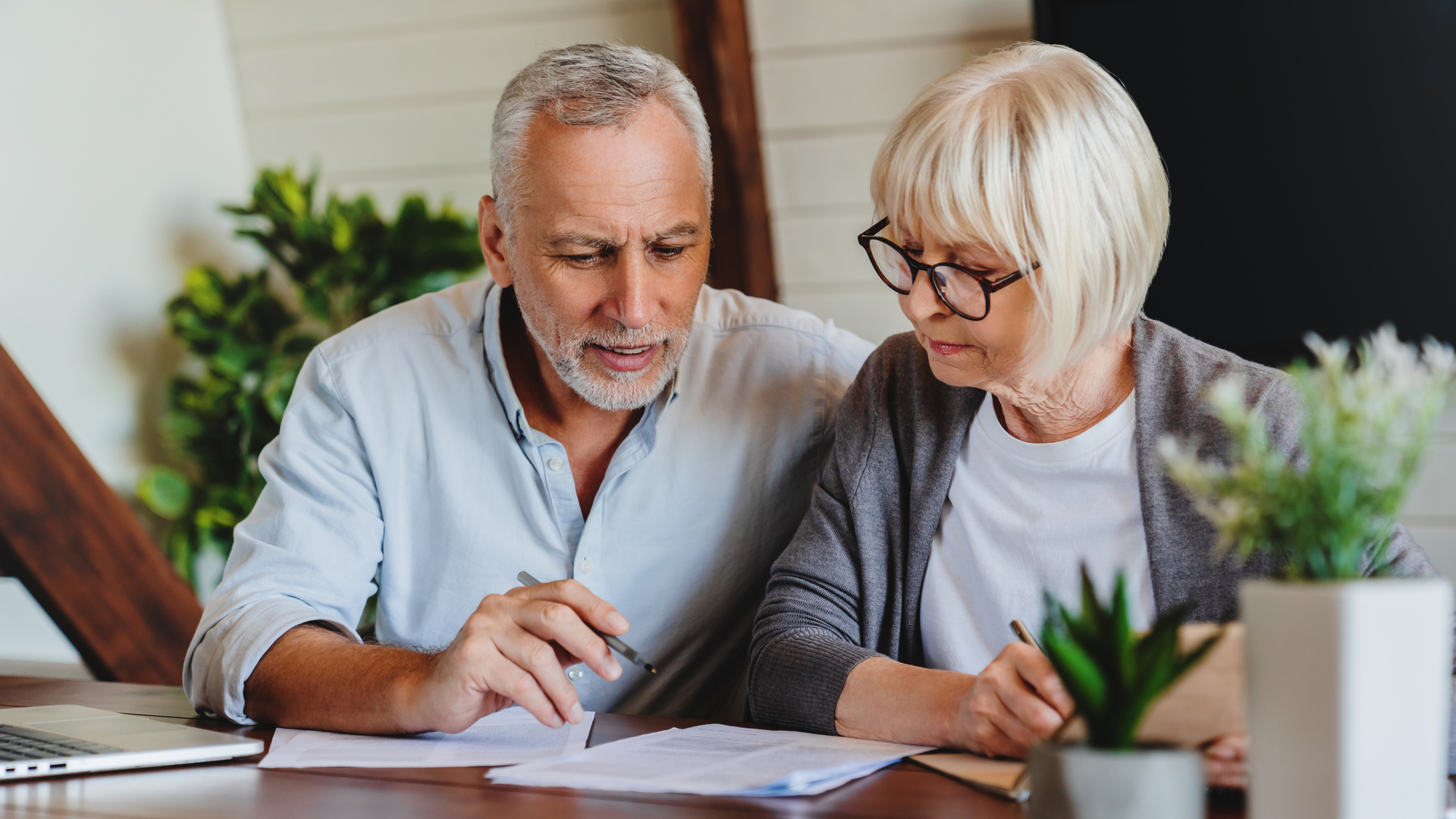 Mature couple with financial documents in home interior