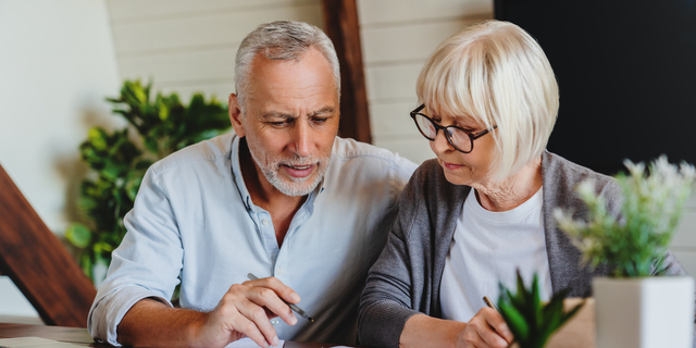 Mature couple with financial documents in home interior