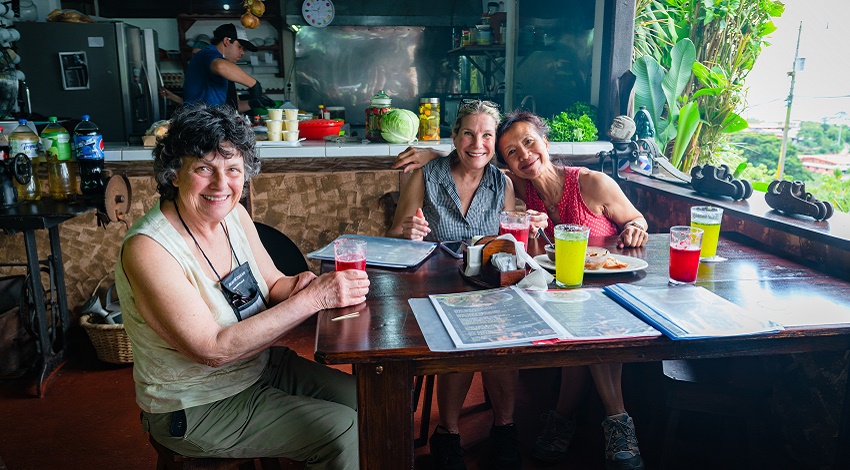 Road Scholars smiling as they enjoy a meal at a Costa Rican restaurant