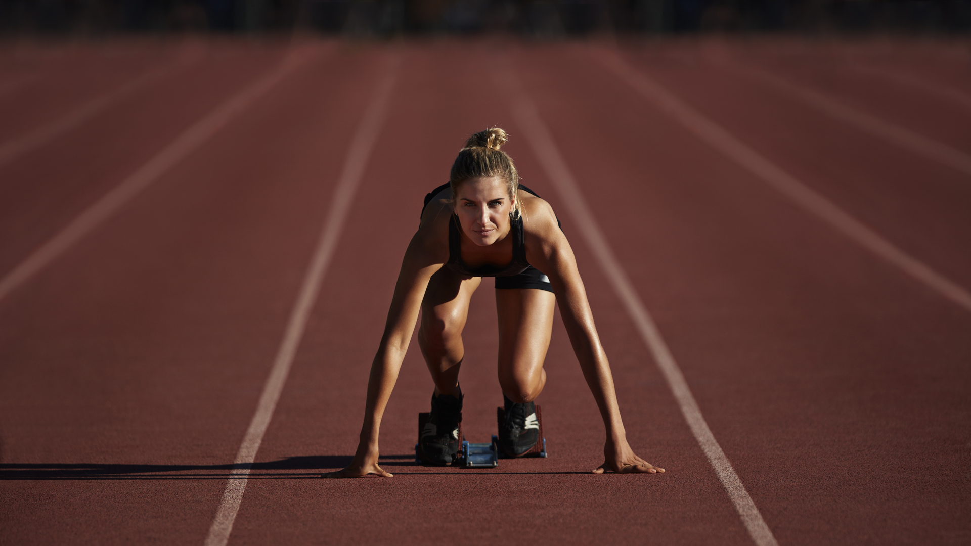 Portrait of female runner in start block