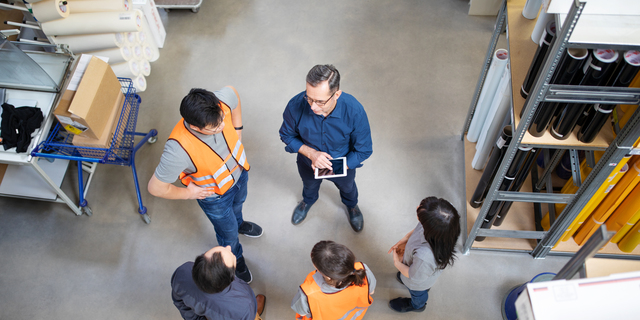 Warehouse manager talking to employees