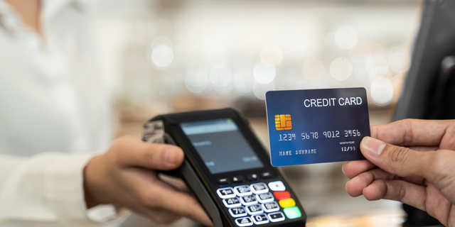 Close up shot of customer hand using dummy credit card for payment to waitress at cashier in cafe restaurant, money cashless and credit card payment technology concept.