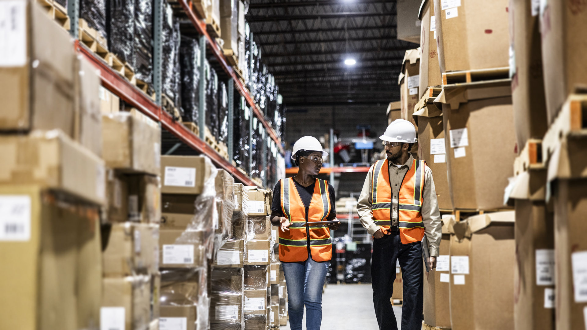 Warehouse employees walking in aisle of warehouse