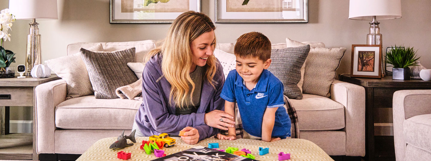 A woman and child play in their living room.