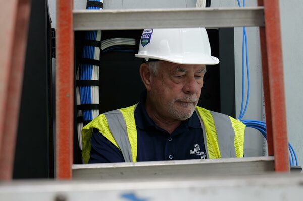 BICSI RCDD certified technician installing network cabling infrastructure on job site