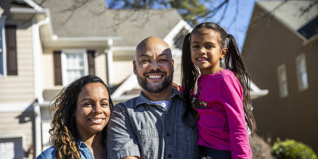 Portrait of family in front of home