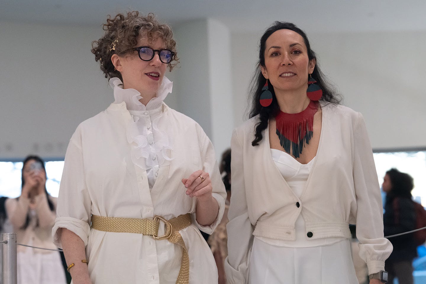 BFA Integrated Design program professors Marisa Morán Jahn and Neva Kocic, creators of the Kite City course, are shown in the Guggenheim Museum dressed in white outfits.   
