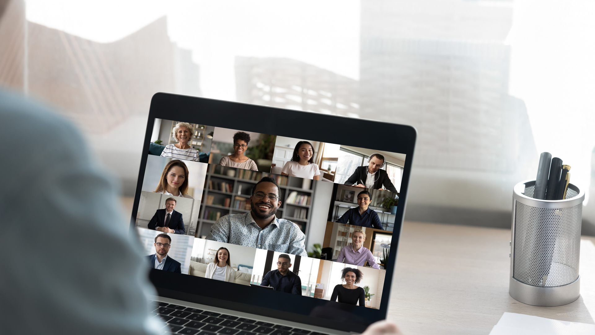 Back view of male employee have webcam conference with colleagues