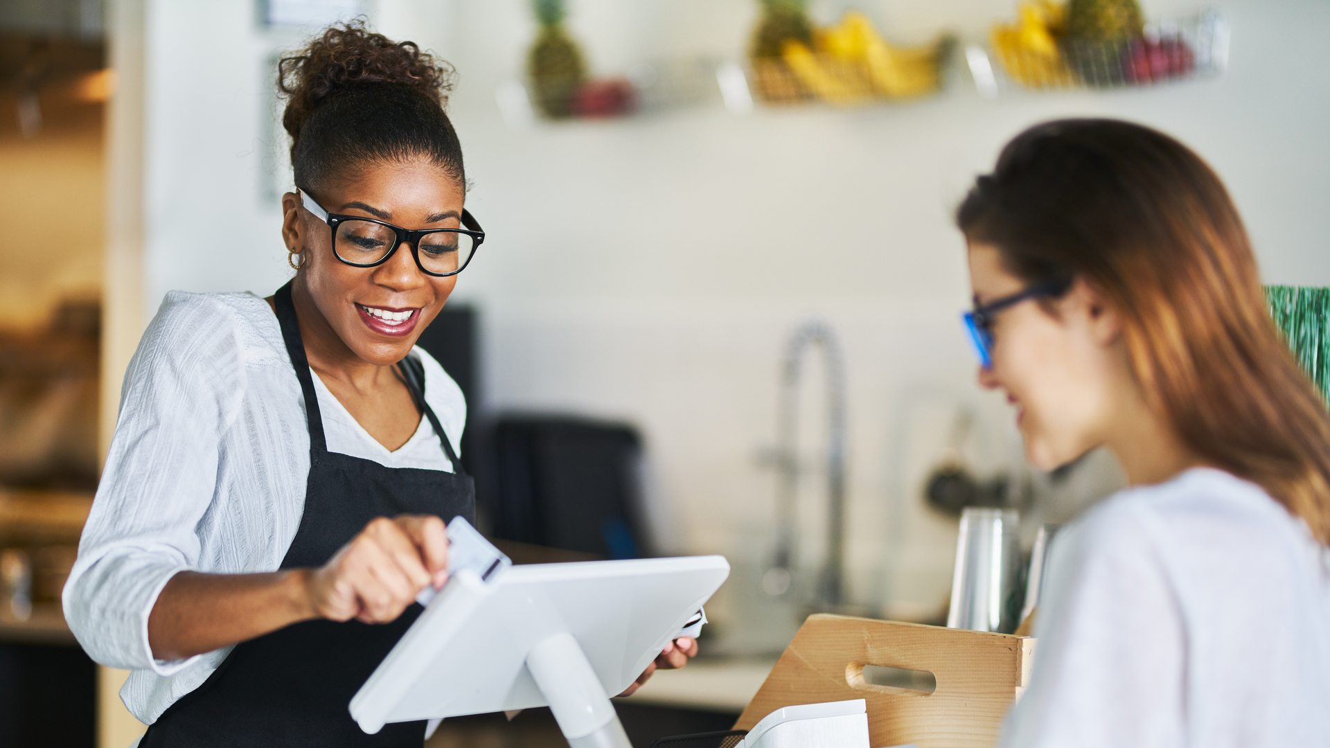 waitress swiping customers bank card on pos terminal at restaurant