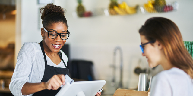 waitress swiping customers bank card on pos terminal at restaurant