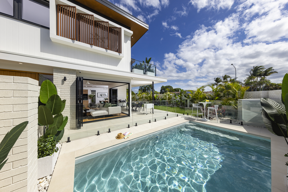 A clear view from a pool area of a double story house