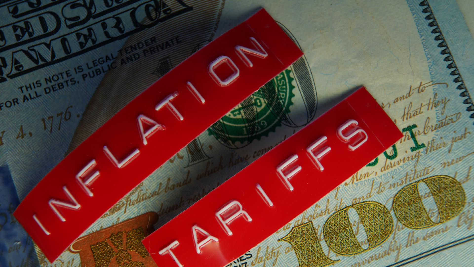 Red Tariffs and Inflation labels on a hundred dollar bill