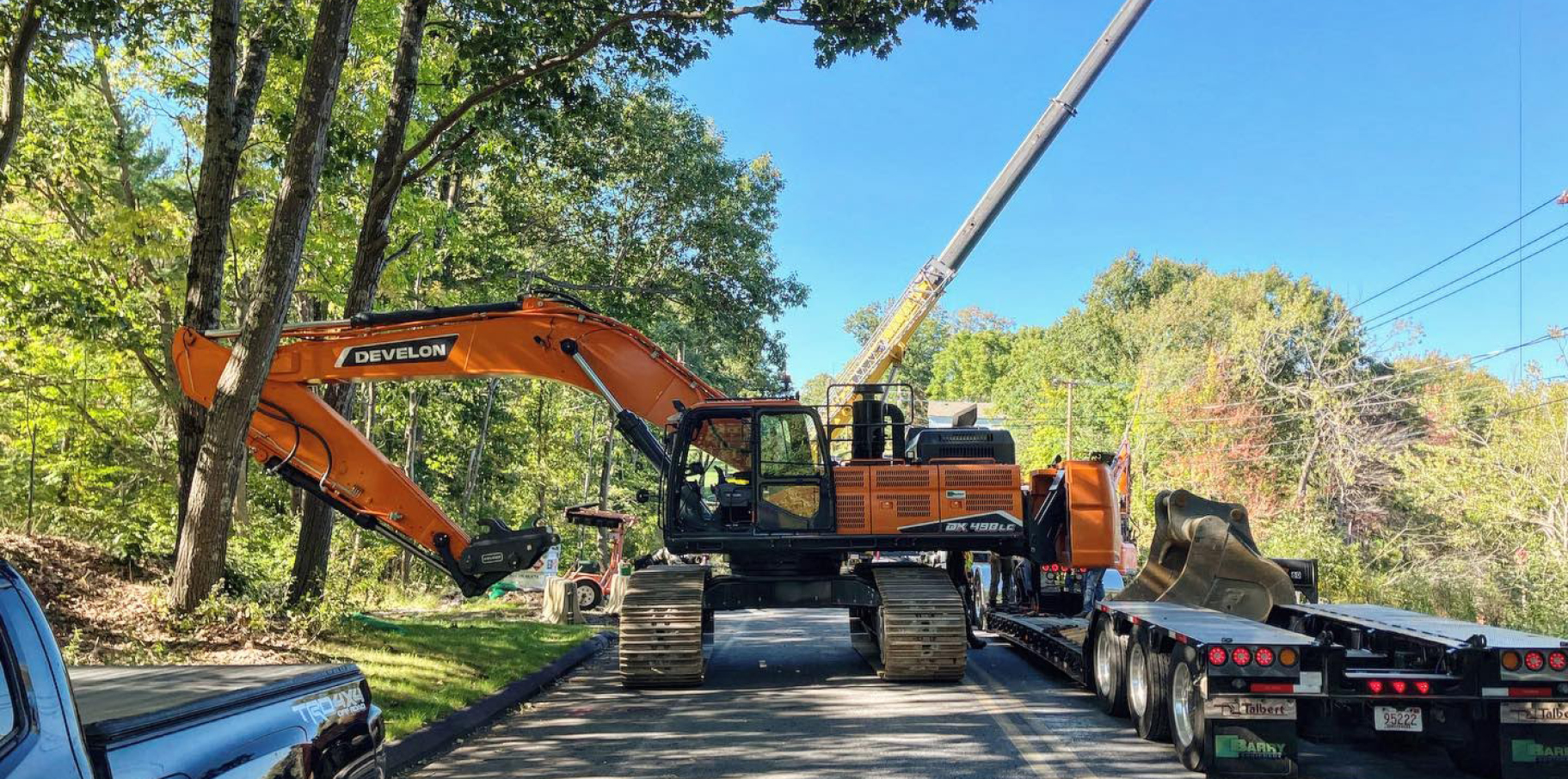 A DEVELON crawler excavator working along a roadside.