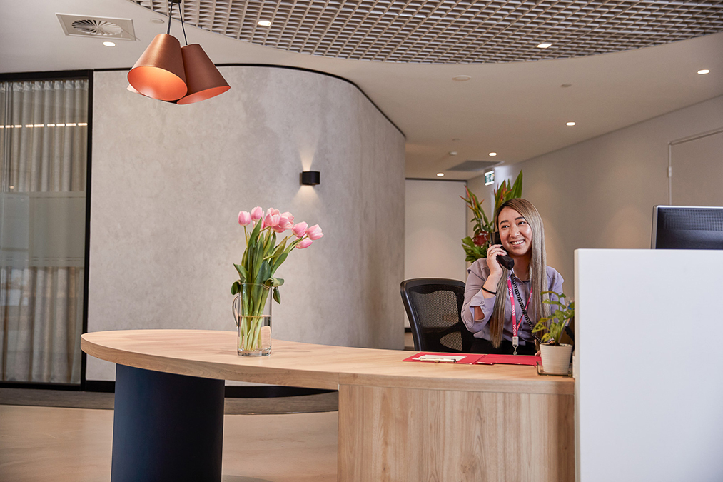 Photo of Vocus receptionist on the phone smiling.