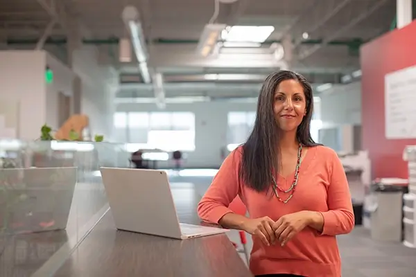 Employee standing with open laptop