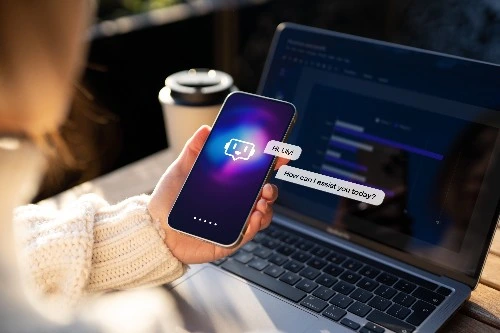 Closeup shot of a hand holding up a mobile phone with an AI chatbot on the screen
