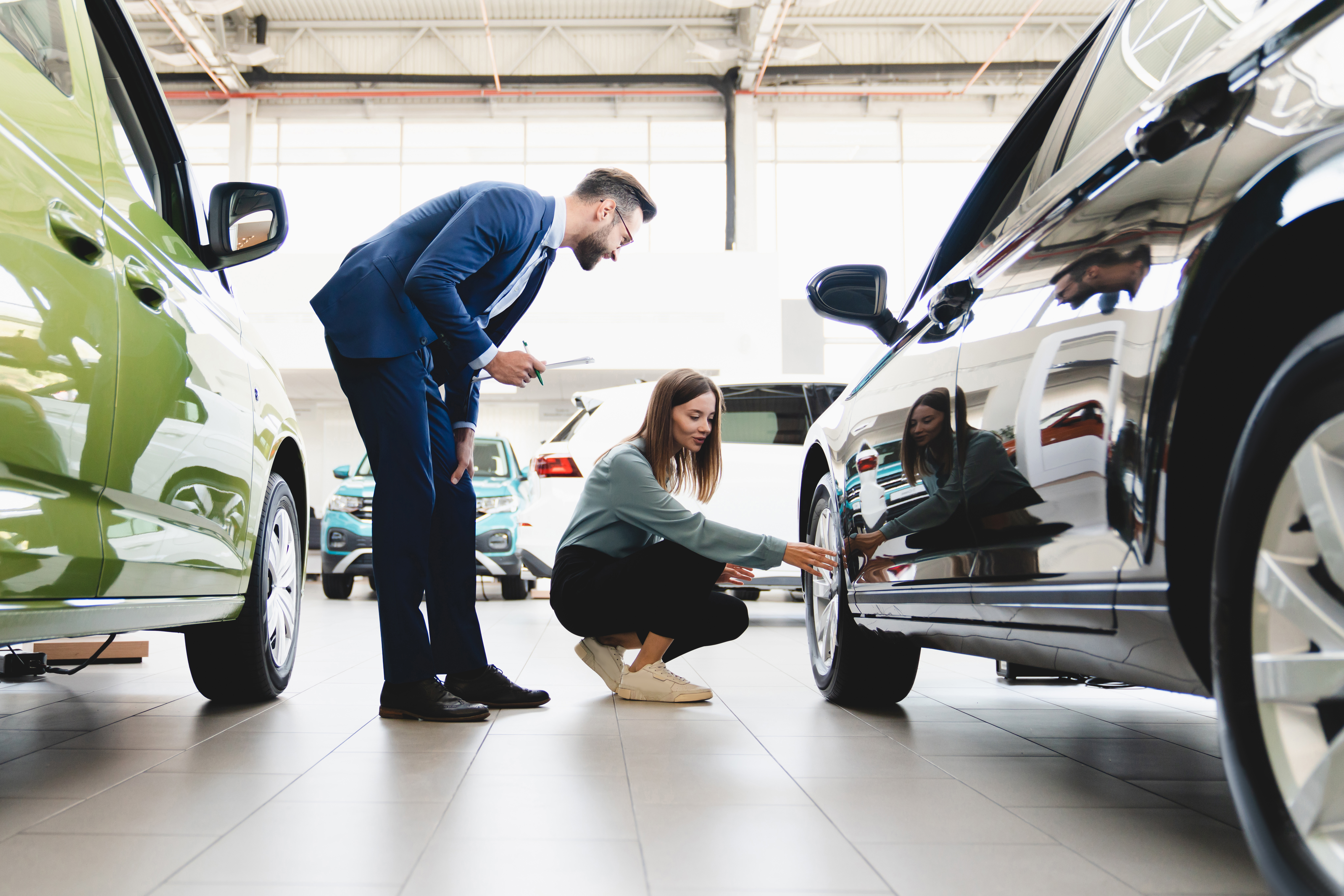 Woman looking at tyres in a showroom with the sales assistant