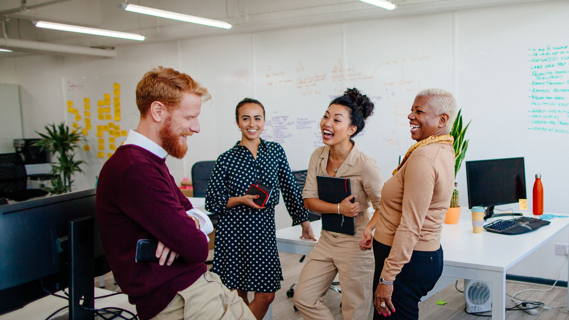 Multi-ethnic group of coworkers laughing together at the office