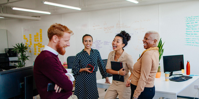 Multi-ethnic group of coworkers laughing together at the office