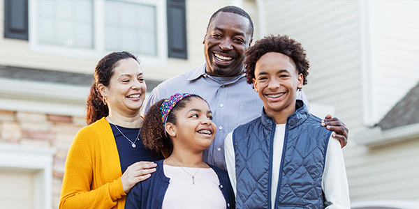 happy black family in front of their home