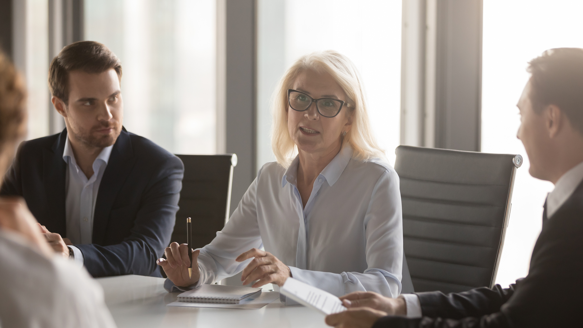 Serious middle aged businesswoman talks at group board executive meeting