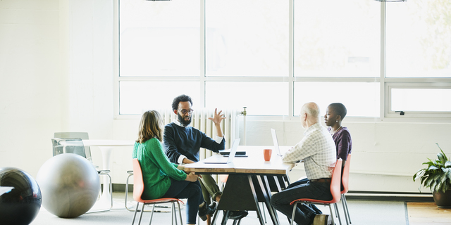 Businessman leading team discussion during meeting at office conference room