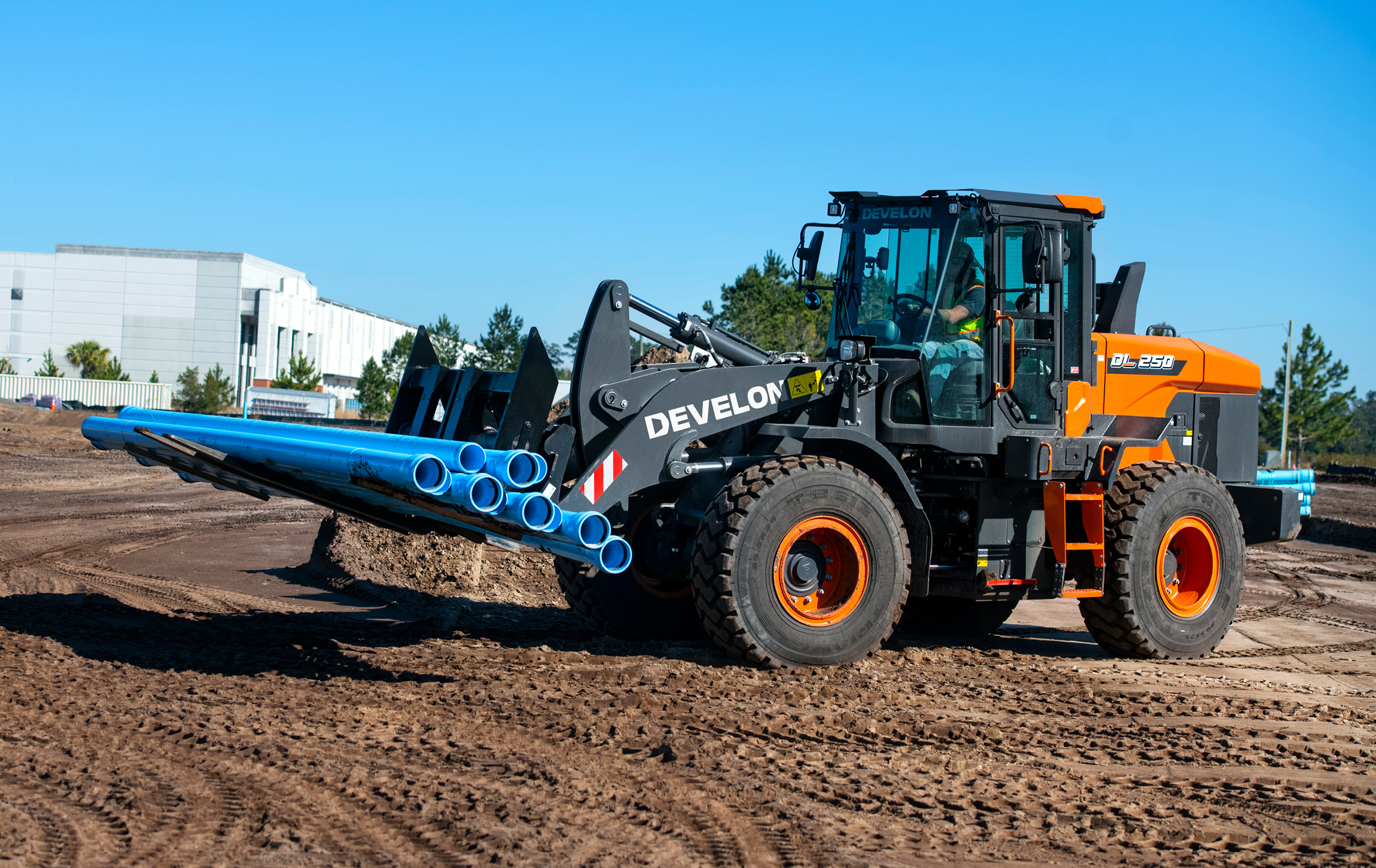 The DEVELON DL250-7 wheel loader hauling a load on a job site.