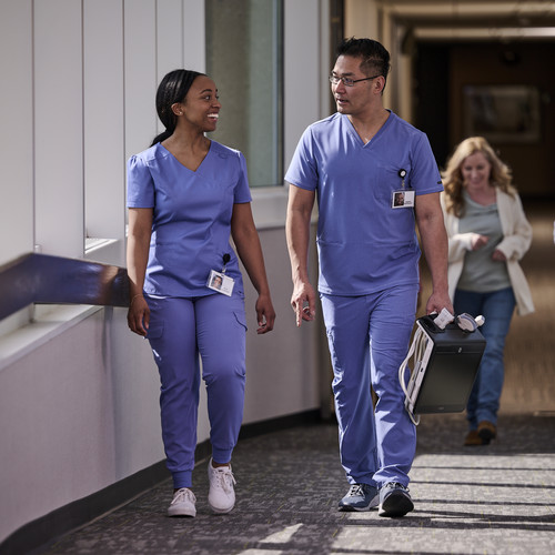 Healthcare workers walking in the hallway with a POUCS system.