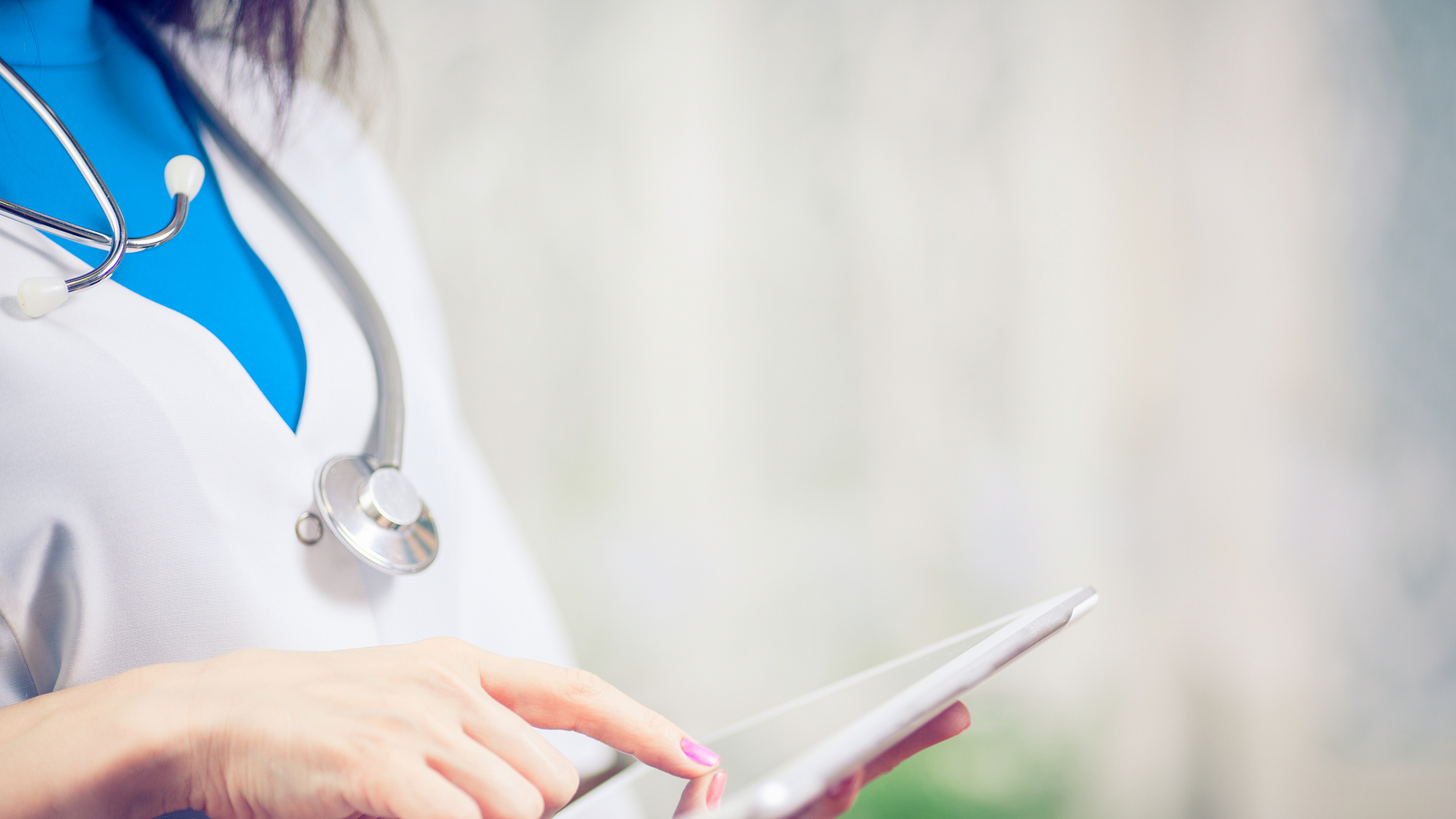 Doctor working on a digital tablet with copy space