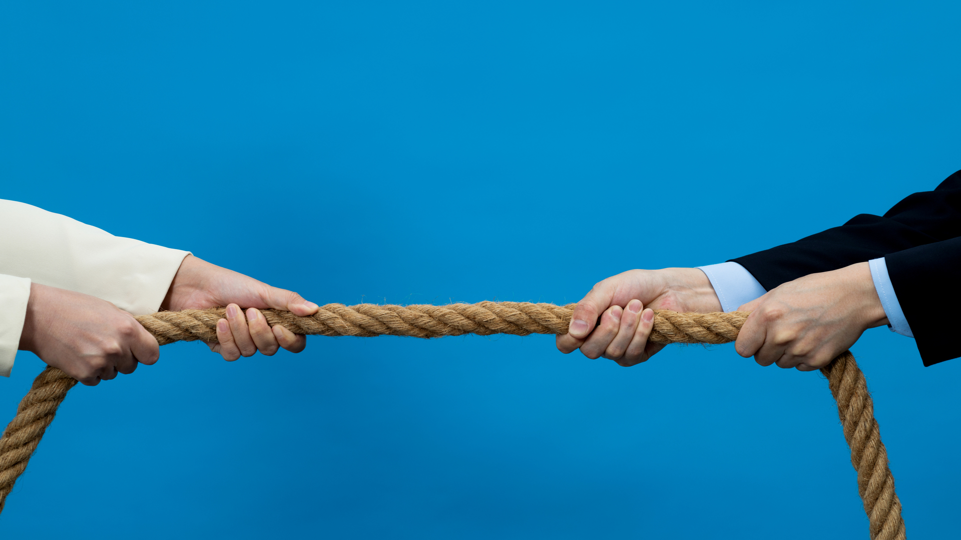 Two business person playing tug-of-war