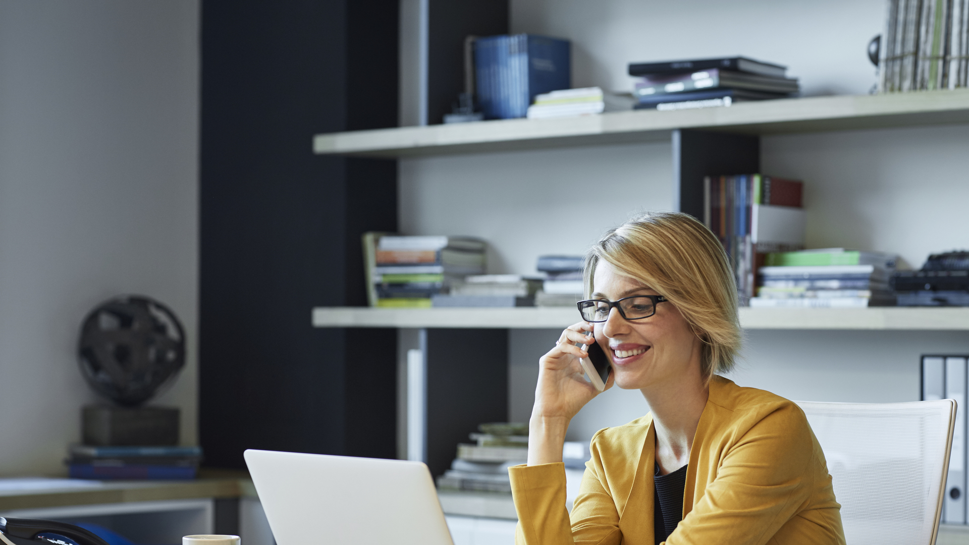 Businesswoman using laptop and smart phone at desk