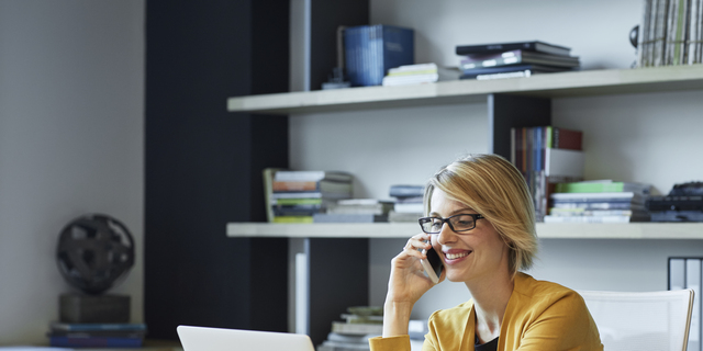 Businesswoman using laptop and smart phone at desk