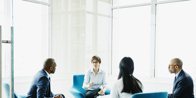 Mature businesswoman leading meeting in office