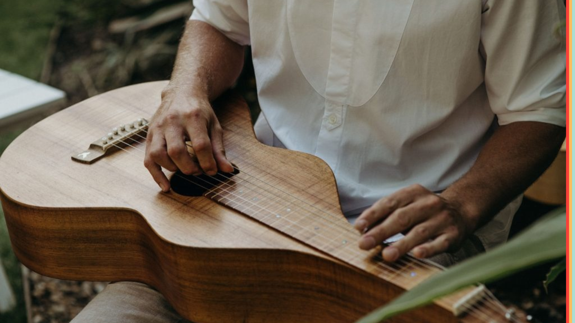 Mattie Barker playing an acoustic guitar during a music session.