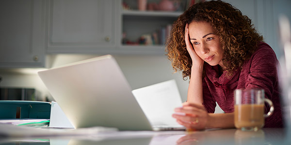 a woman looks at paperwork with a look of worry on her face